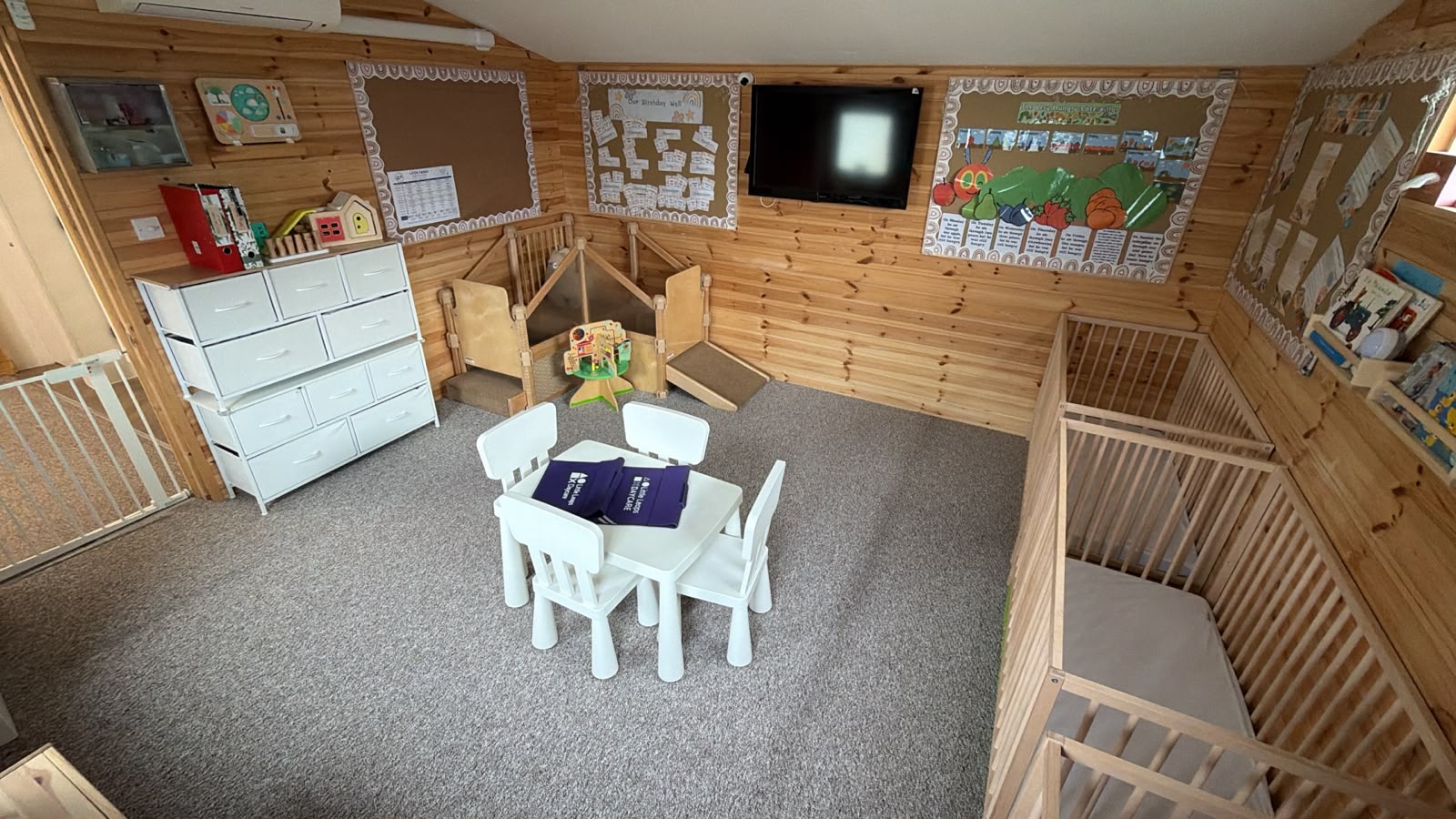 A wide Basildon room view with low furniture, soft carpet and nursery displays