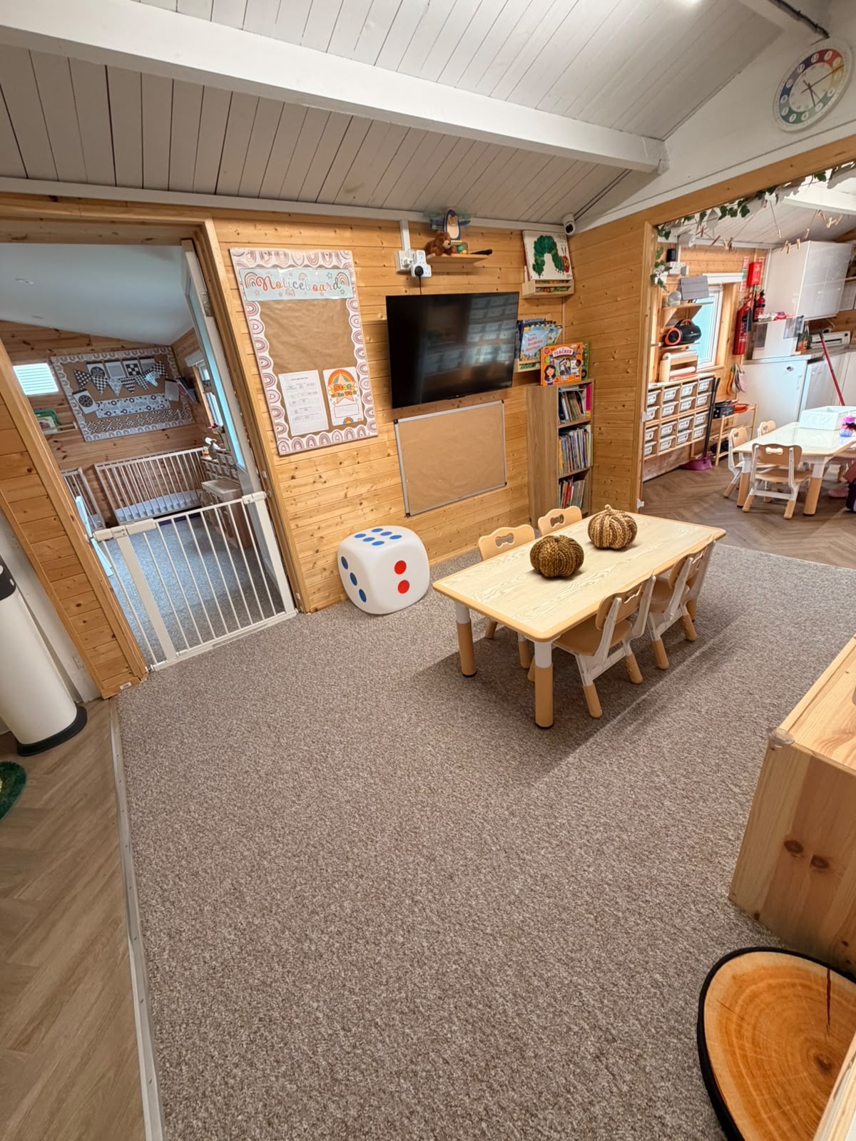 A Basildon indoor nursery room with low tables, accessible resources and adjoining play spaces