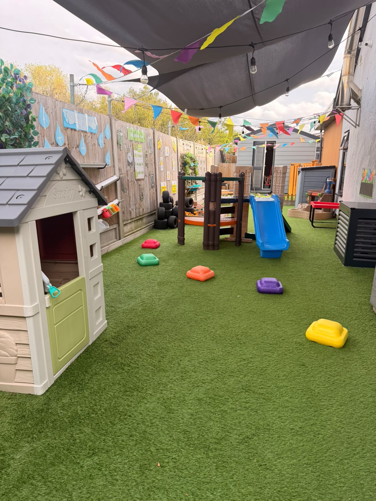A second view of the Basildon garden with play house, climbing equipment and artificial grass