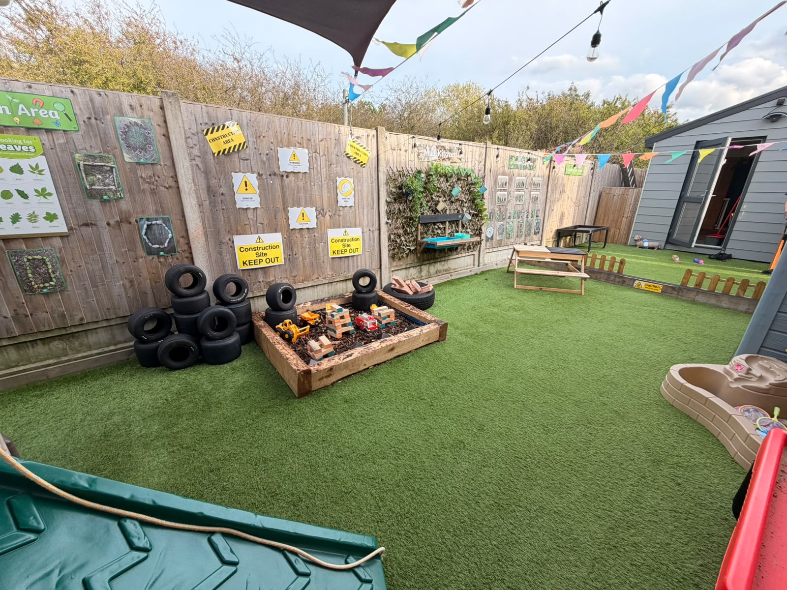 The Basildon outdoor garden with construction play, artificial grass and outdoor learning areas